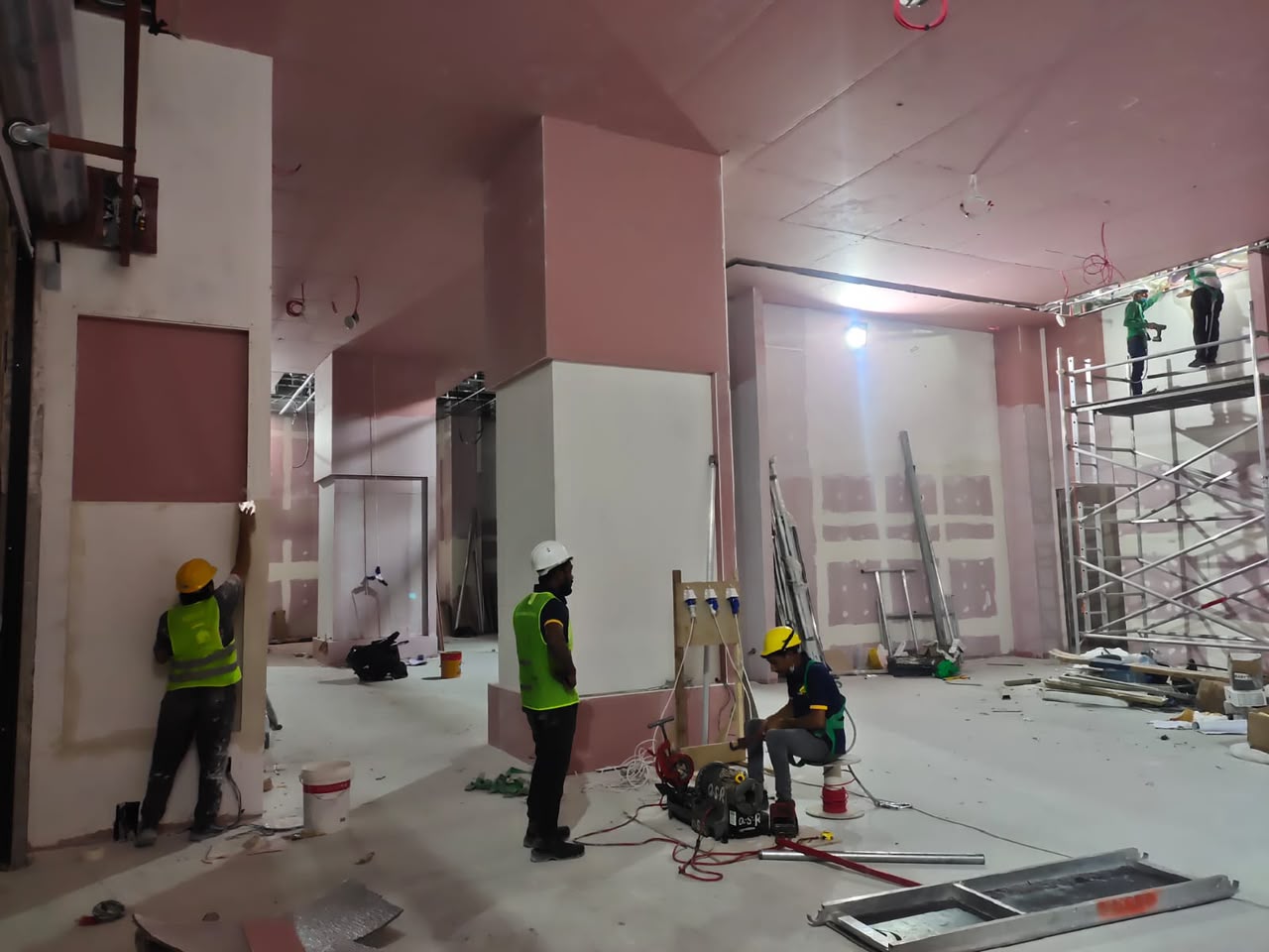 Workers finishing drywall columns on an active contracting site