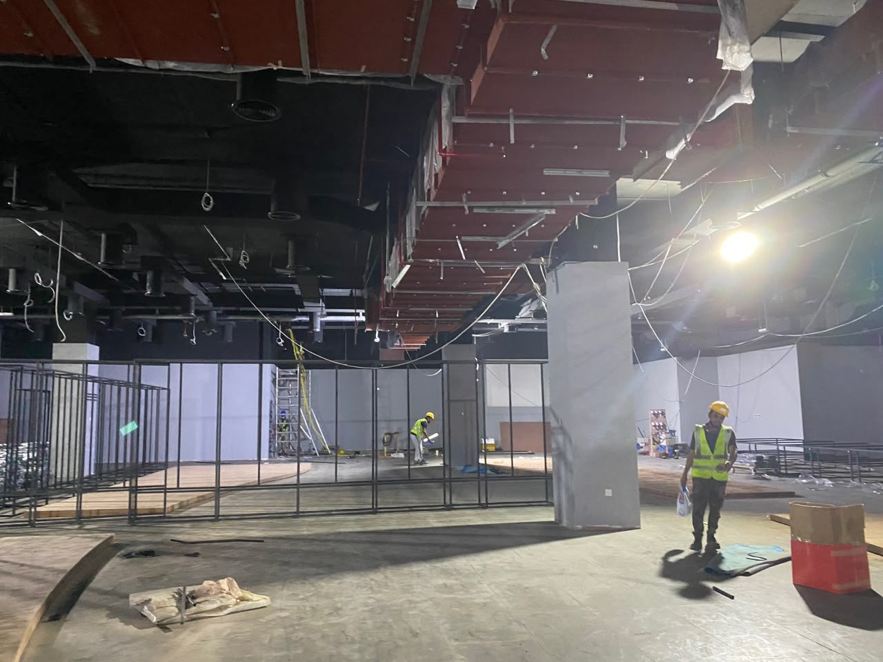 Scaffolding towers set up for ceiling work in an unfinished retail space
