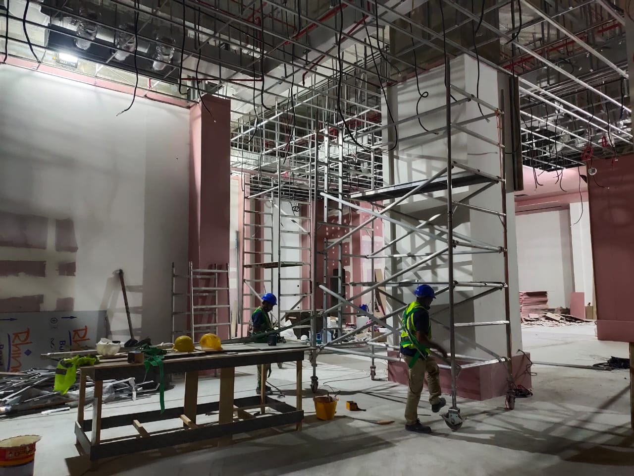 Contracting team working from scaffolding on a commercial ceiling grid