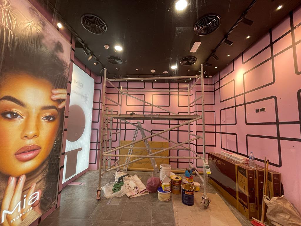 Retail store fit-out in progress with branded wall graphics and scaffolding