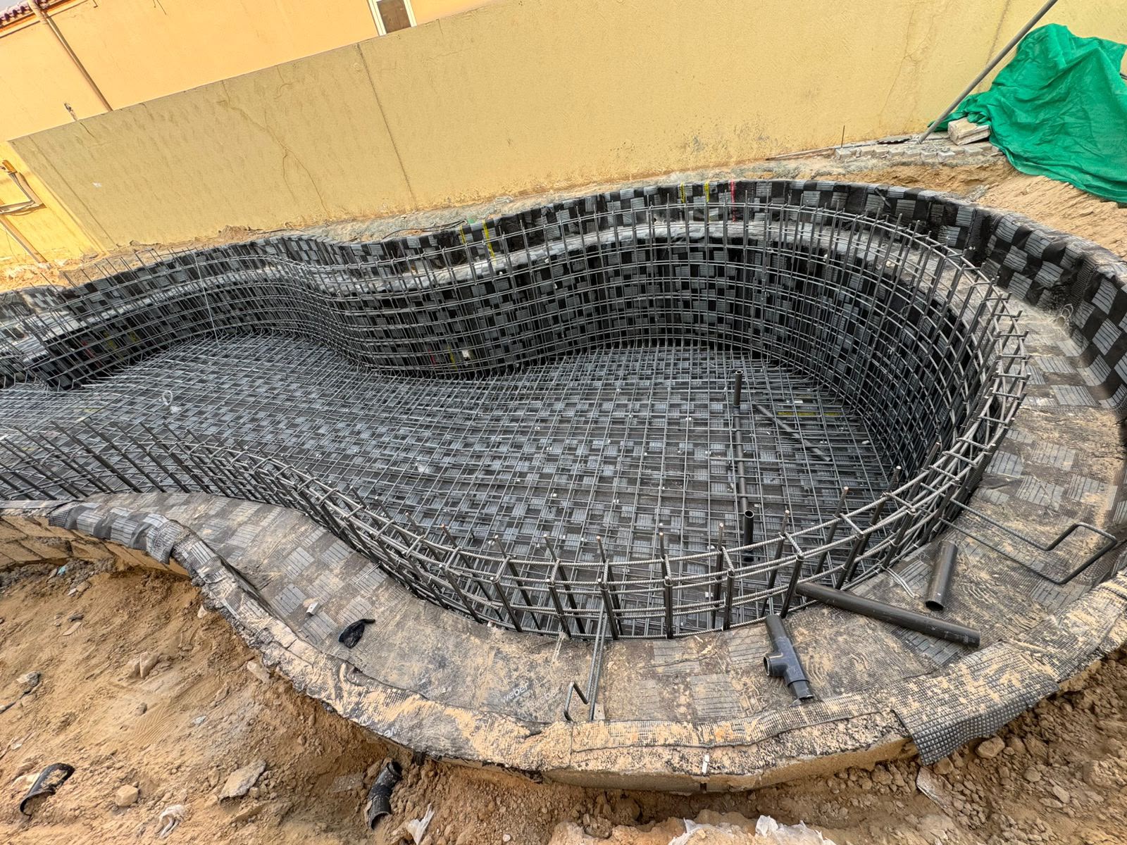 Curved swimming pool structure with steel reinforcement and timber formwork