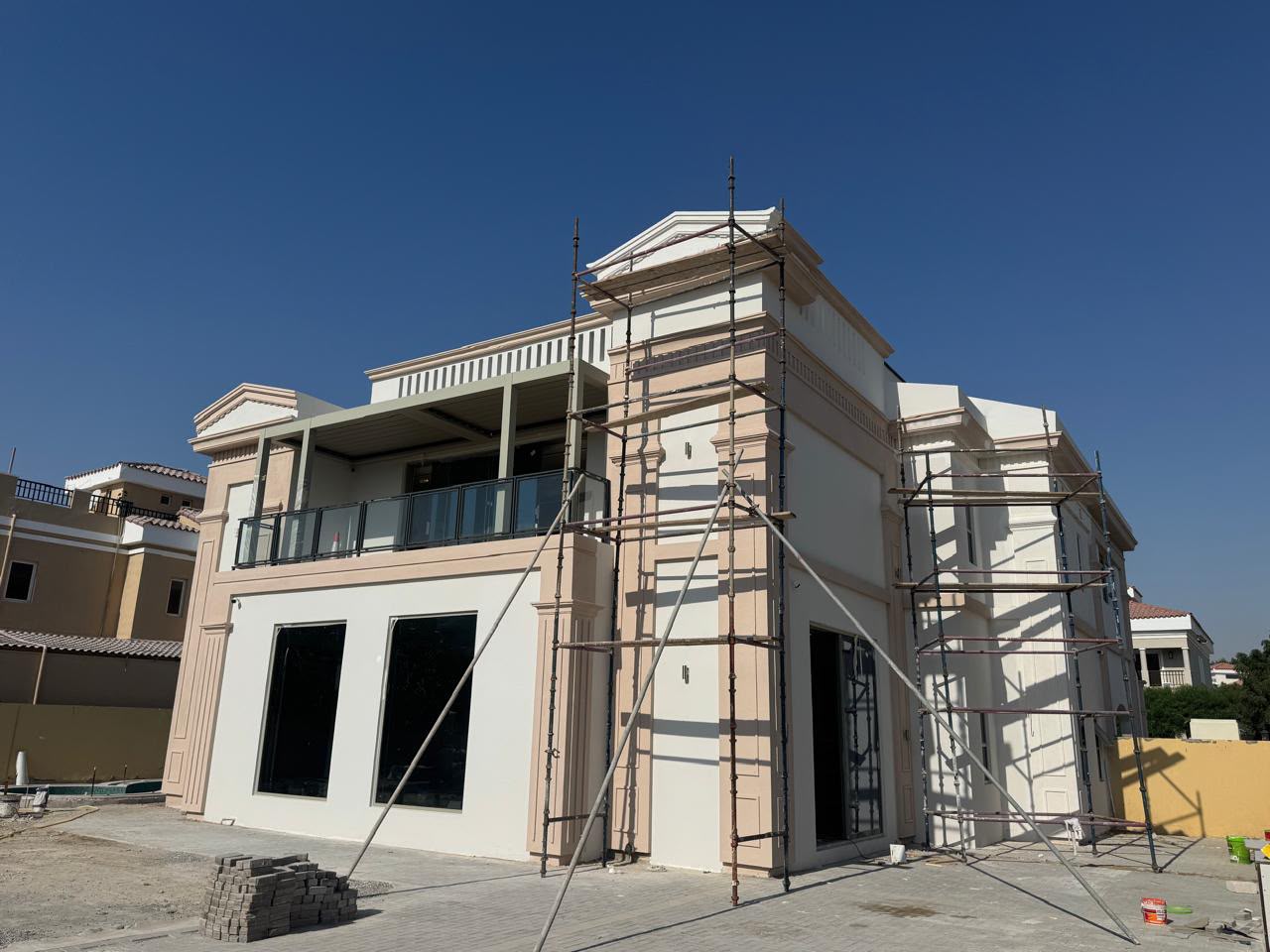 Villa exterior with classical facade detailing under construction and scaffolding