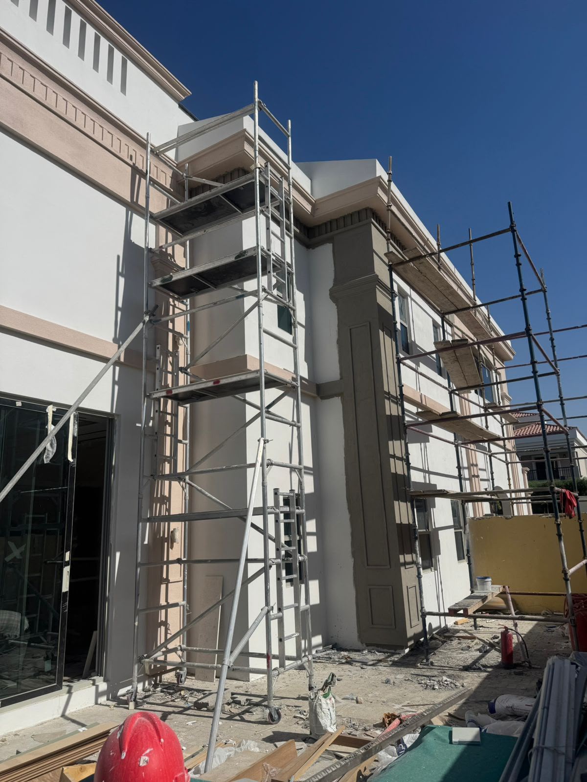 Close-up of scaffolding against a villa's decorative stone facade column